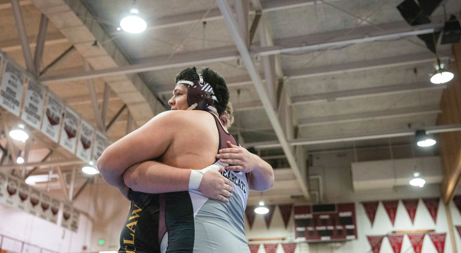 W.F. West senior Daniel Matagi embraces Zeke Luchi of Enumclaw after wrestling at 285 pounds during the Bearcat Invitational at his last home meet in Chehalis Saturday night.